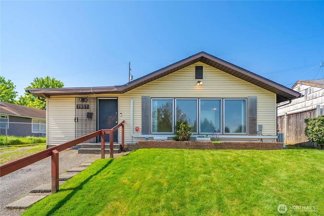 rear view of house with a yard and fence