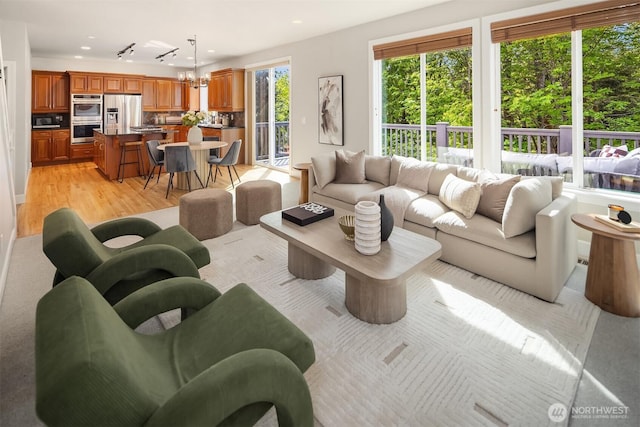 living room with light wood-style floors, recessed lighting, and a chandelier