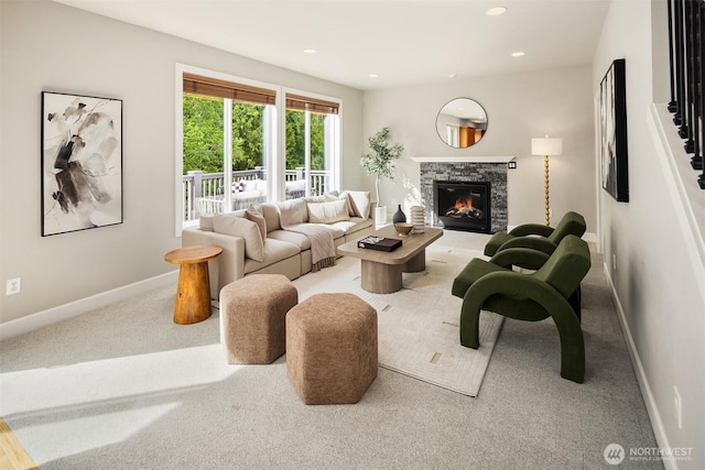 living area with carpet flooring, a stone fireplace, baseboards, and recessed lighting