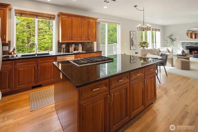 kitchen with a sink, stainless steel appliances, decorative backsplash, light wood-type flooring, and recessed lighting