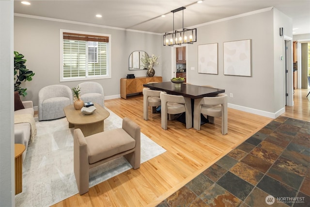 dining space with baseboards, crown molding, recessed lighting, wood finished floors, and a chandelier