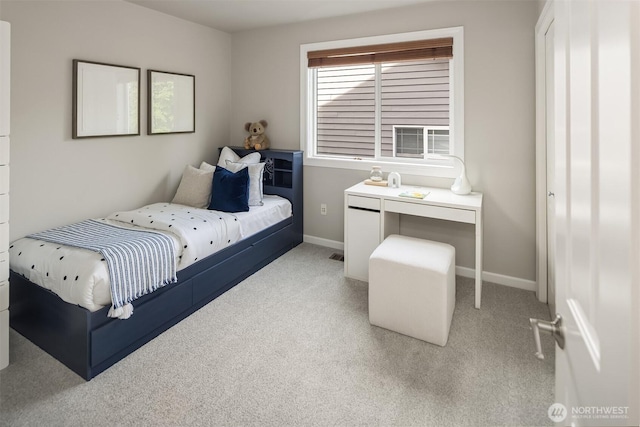 bedroom with light colored carpet and baseboards
