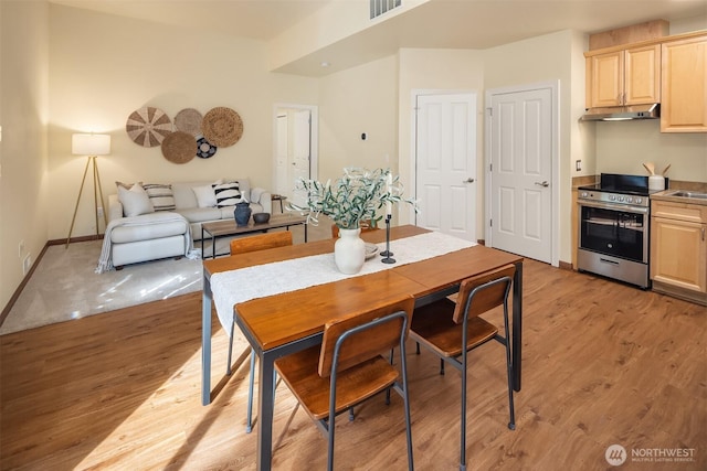 dining area featuring light wood-type flooring and baseboards