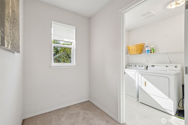 laundry area featuring laundry area, visible vents, washing machine and dryer, baseboards, and light carpet
