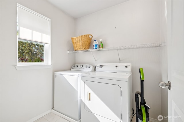 washroom with light tile patterned floors, separate washer and dryer, baseboards, and laundry area