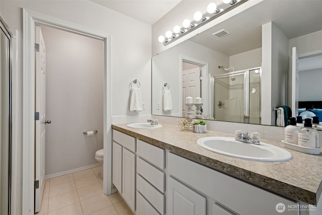 bathroom with a sink, double vanity, toilet, tile patterned floors, and a stall shower