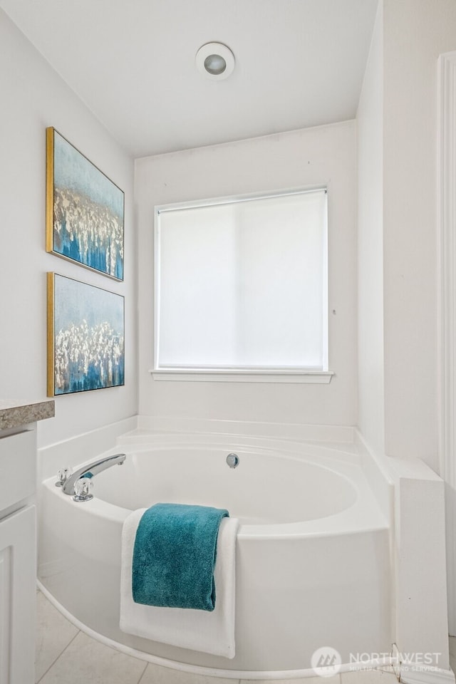 full bathroom with a wealth of natural light, a bath, and vanity