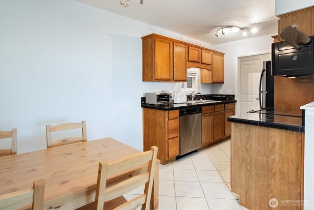 kitchen featuring stainless steel dishwasher, a sink, light tile patterned floors, and brown cabinets