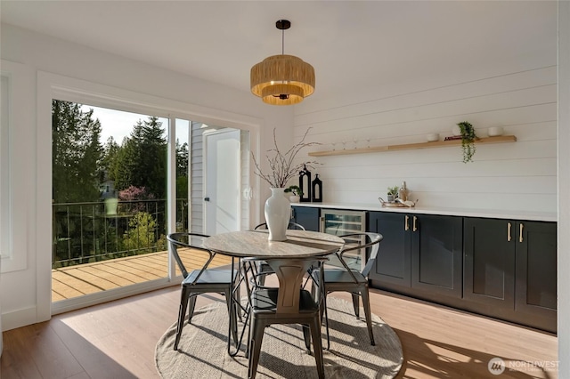 321 Bellevue Way SE Unit 401, Bellevue, WA 98004 - dining area featuring a dry bar, wooden walls, light wood-style floors, and wine cooler