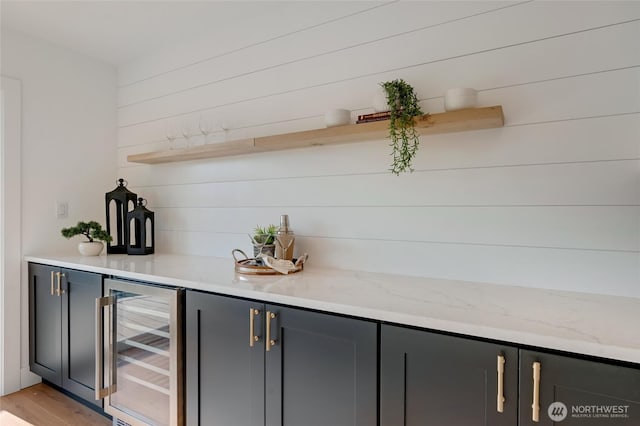 321 Bellevue Way SE Unit 401, Bellevue, WA 98004 - bar featuring beverage cooler, wooden walls, light wood finished floors, and wet bar