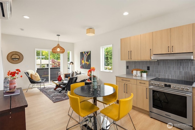 3650 51st Ave SW Unit B, Seattle, WA 98116 - kitchen featuring stainless steel range with electric stovetop, under cabinet range hood, light brown cabinetry, tasteful backsplash, and light wood finished floors