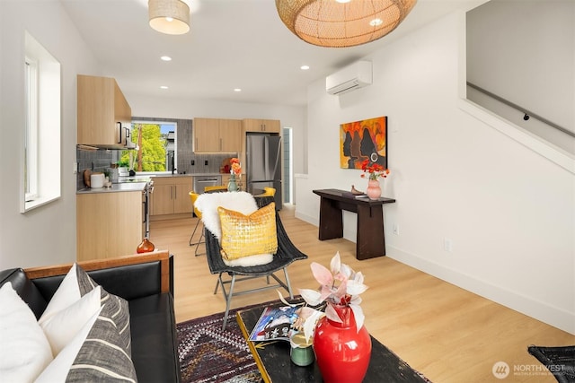 3650 51st Ave SW Unit B, Seattle, WA 98116 - living room with a wall unit AC, light wood finished floors, recessed lighting, and baseboards