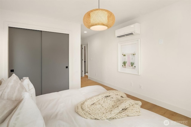 3650 51st Ave SW Unit B, Seattle, WA 98116 - bedroom with a wall unit AC, a closet, wood finished floors, baseboards, and recessed lighting
