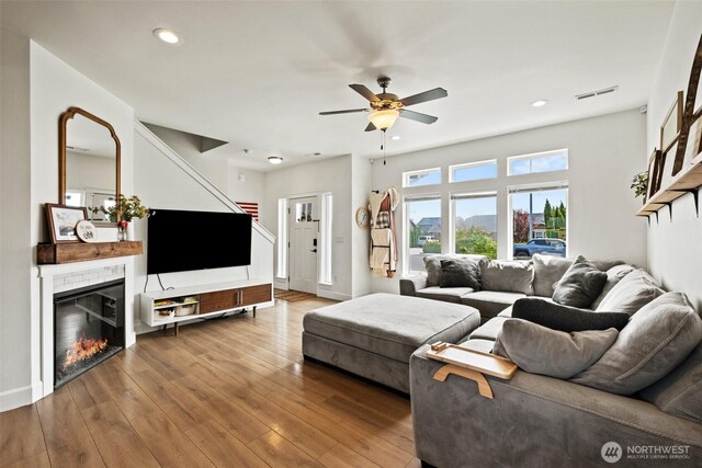 living room featuring recessed lighting, ceiling fan, visible vents, and wood finished floors
