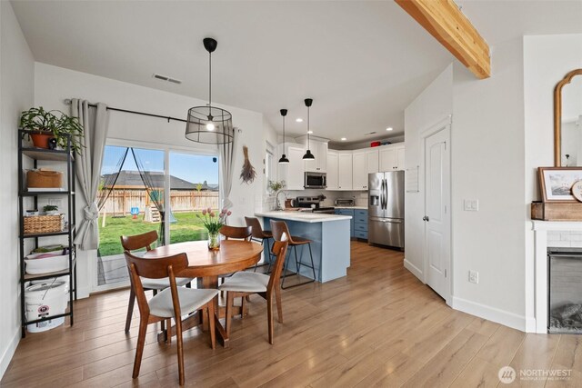 dining room with recessed lighting, light wood-type flooring, beam ceiling, and visible vents