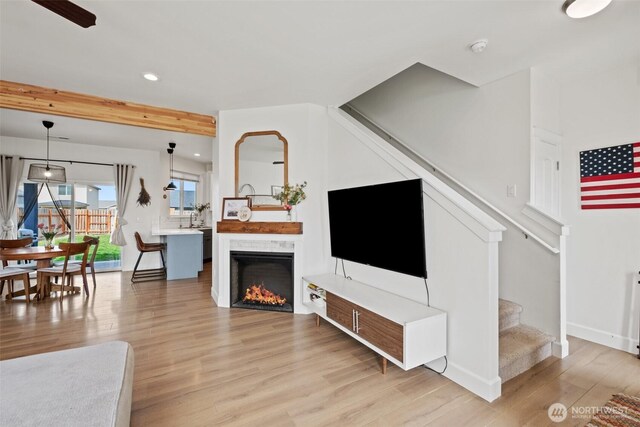 living area featuring recessed lighting, baseboards, light wood-type flooring, and stairs