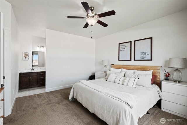 carpeted bedroom featuring baseboards, a sink, connected bathroom, and a ceiling fan