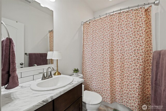 bathroom with toilet, a shower with curtain, and vanity