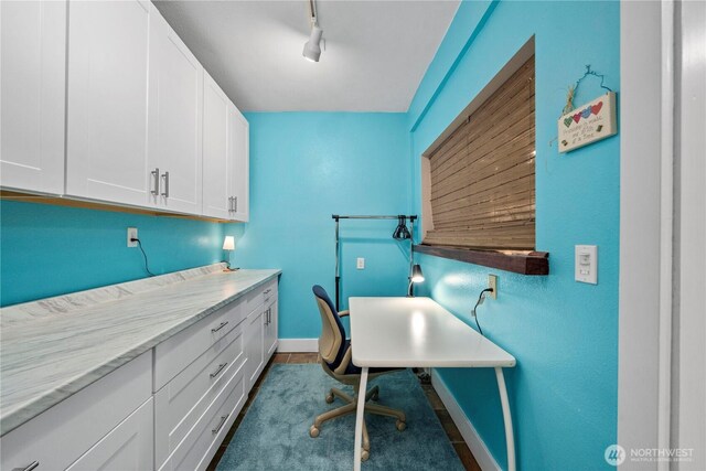 office area with baseboards and rail lighting