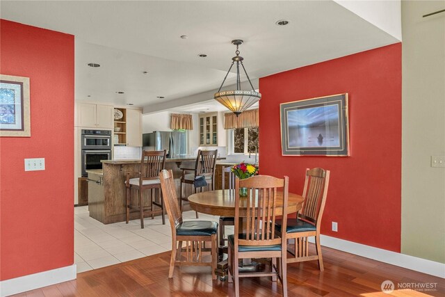 dining area featuring light wood-type flooring, baseboards, and recessed lighting