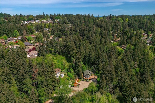 aerial view of property's location featuring a forest