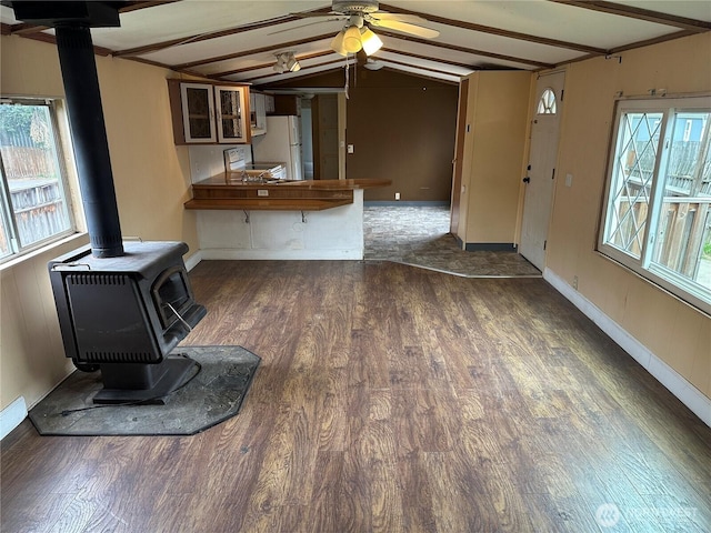10206 218th Ave E, Bonney Lake, WA 98391 - unfurnished living room featuring a wood stove, wood finished floors, a ceiling fan, baseboards, and lofted ceiling