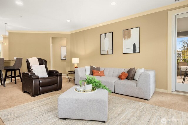 living room featuring crown molding, baseboards, and light colored carpet