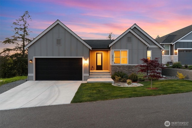 modern farmhouse style home with a yard, board and batten siding, concrete driveway, and stone siding