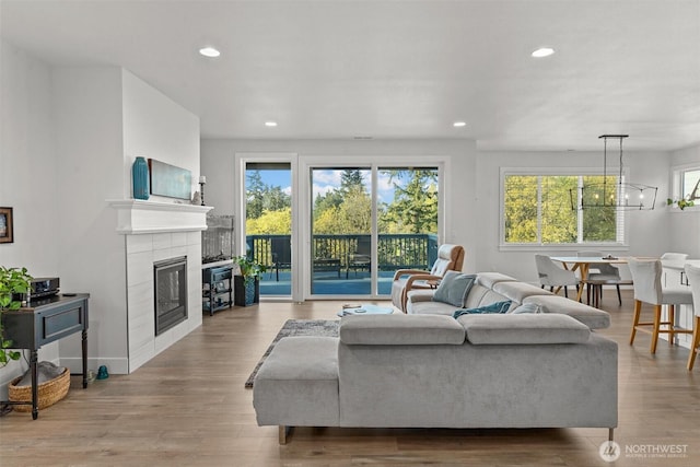 living room with recessed lighting, wood finished floors, a chandelier, and a fireplace