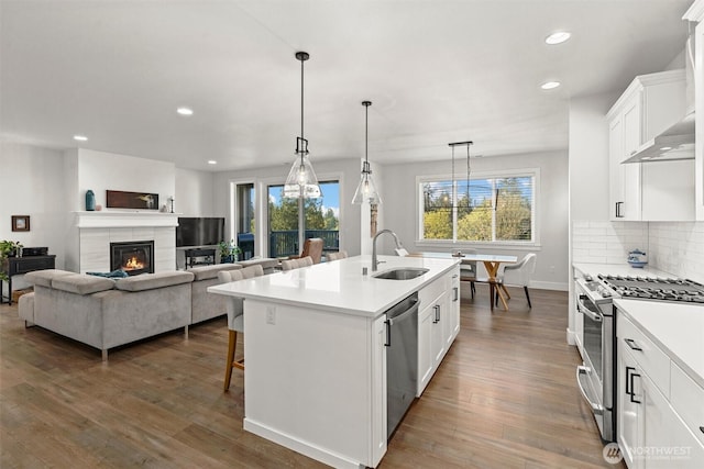 kitchen with recessed lighting, light countertops, white cabinetry, a sink, and appliances with stainless steel finishes