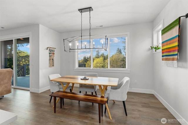 dining room featuring baseboards, a chandelier, wood finished floors, and visible vents