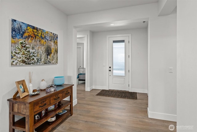 foyer entrance with baseboards and wood finished floors
