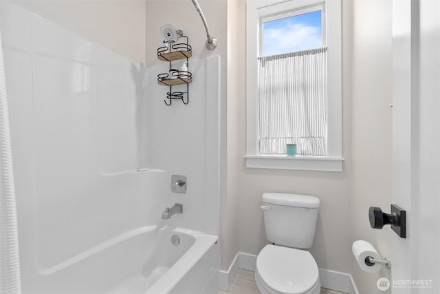 full bathroom featuring toilet, baseboards, and shower / washtub combination