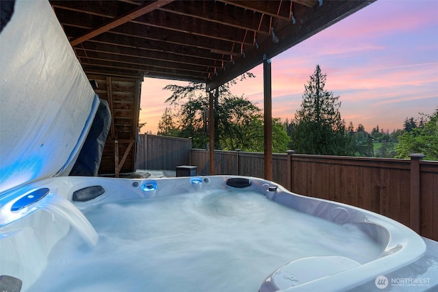 view of patio / terrace featuring a hot tub and fence