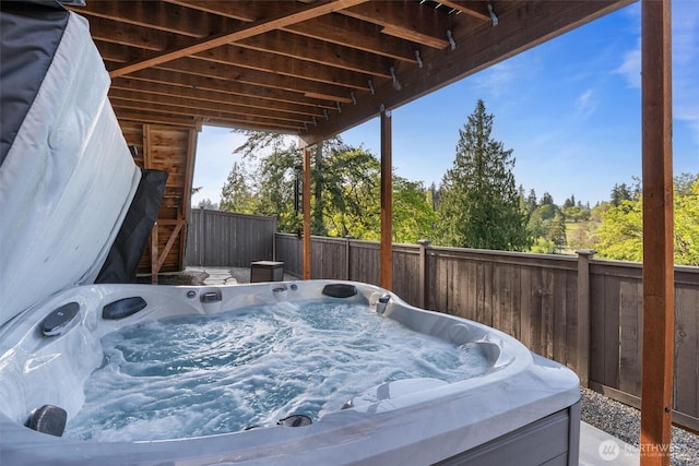 wooden deck featuring a fenced backyard and a hot tub