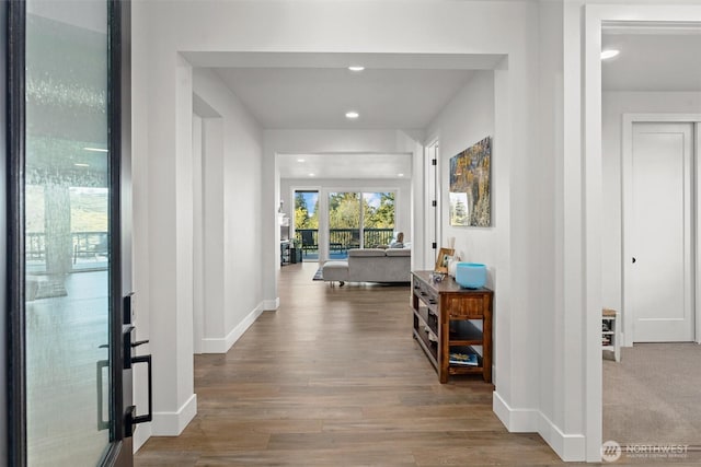 hall featuring baseboards, recessed lighting, wood finished floors, and french doors