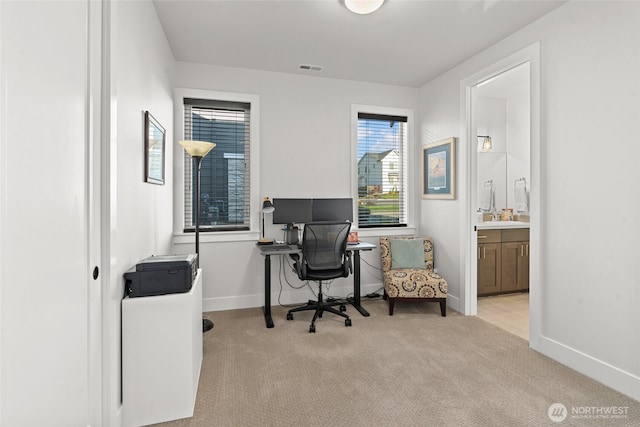 home office featuring baseboards, light carpet, and visible vents