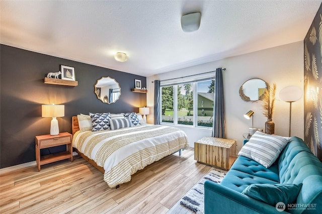 bedroom with light wood-style flooring and a textured ceiling