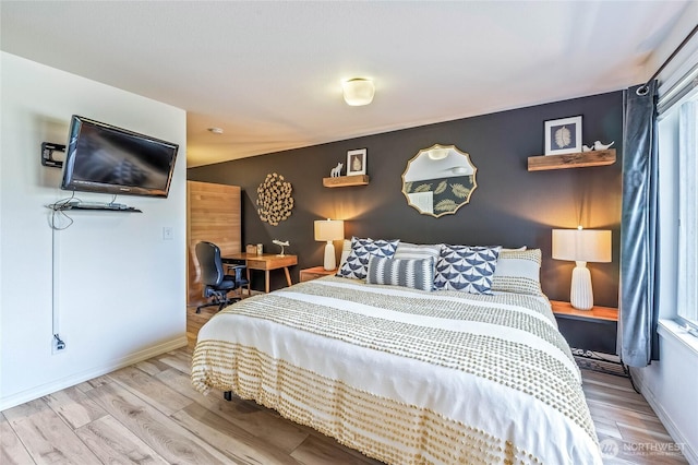 bedroom with light wood finished floors and baseboards