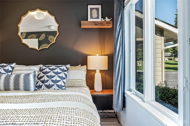 bedroom featuring multiple windows and wood finished floors
