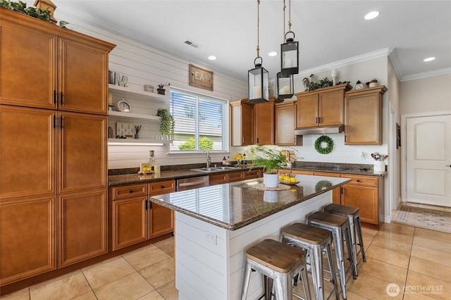 kitchen featuring crown molding, brown cabinets, and under cabinet range hood
