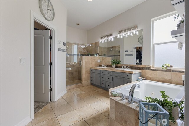full bath with double vanity, a shower stall, a sink, tile patterned floors, and a whirlpool tub