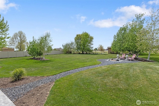 view of yard with fence and a fire pit