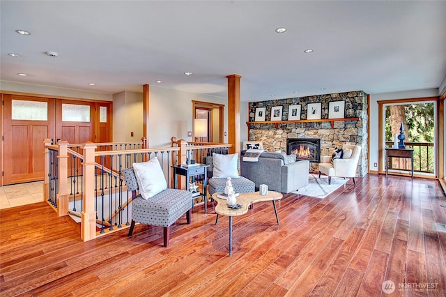 living room with light wood-type flooring, a fireplace, and recessed lighting