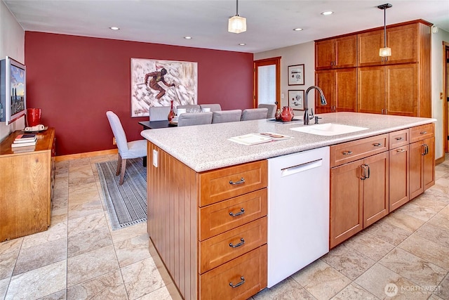 kitchen with a sink, light countertops, white dishwasher, brown cabinetry, and hanging light fixtures