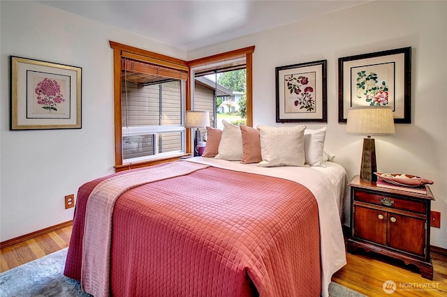 bedroom featuring wood finished floors and baseboards