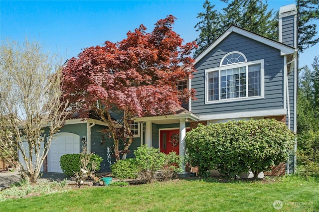 view of front of property with an attached garage, a chimney, and a front yard