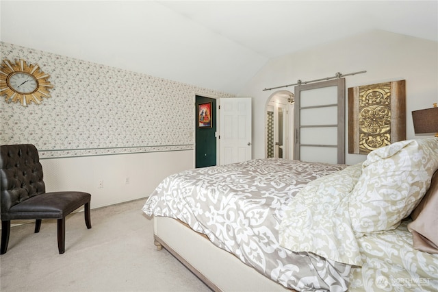 bedroom with light colored carpet, wallpapered walls, and lofted ceiling