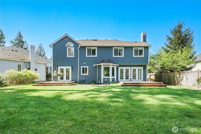 rear view of house featuring a chimney, fence, french doors, and a deck
