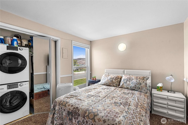 bedroom featuring stacked washing maching and dryer, carpet flooring, and a closet